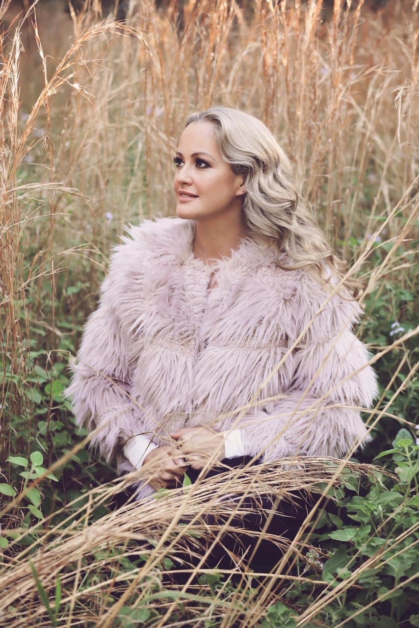 Lissy Katriona, in a soft lavender coat among golden field grasses