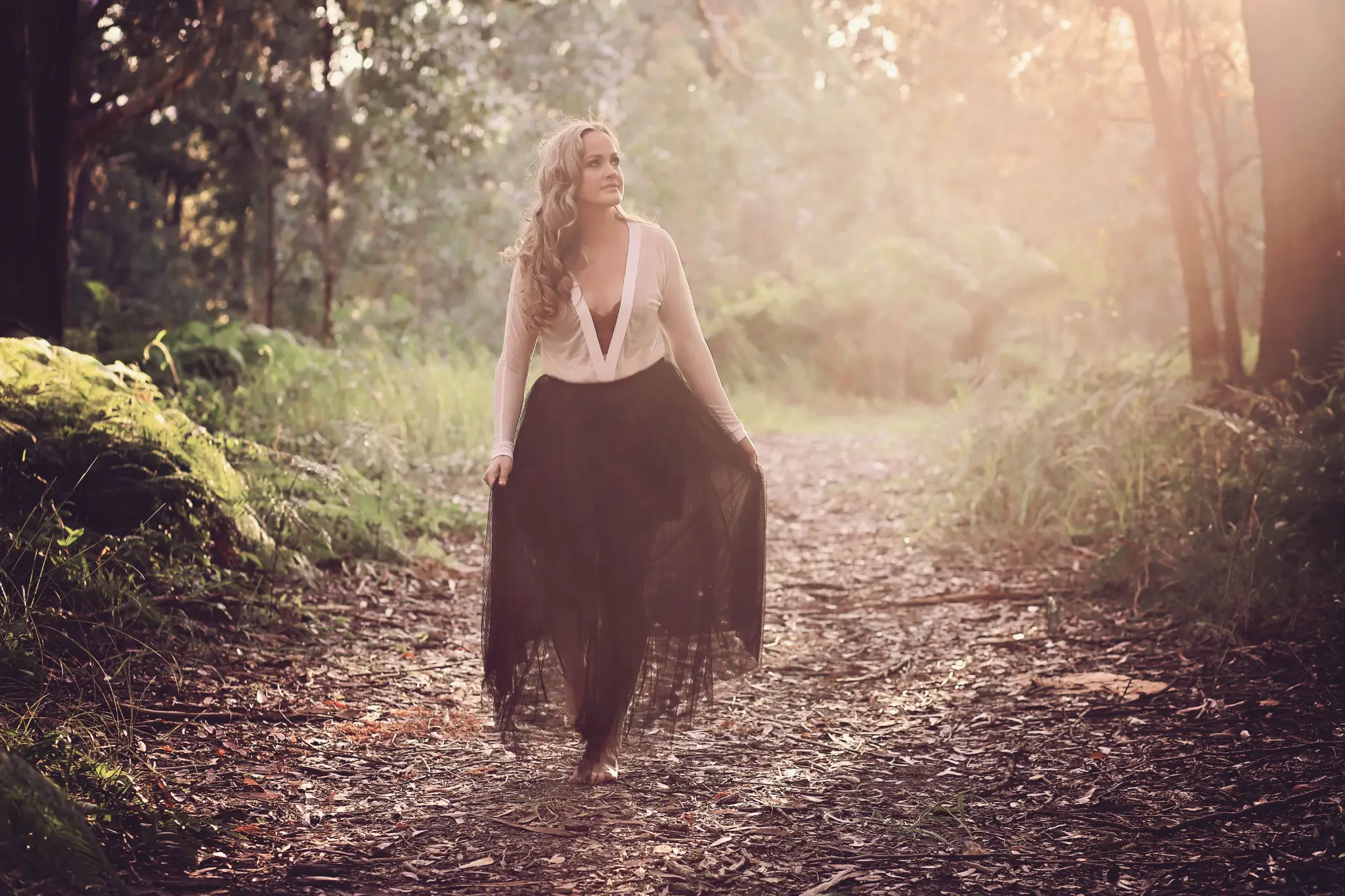 Lissy Katriona, walking barefoot through the Australian bushland at golden hour
